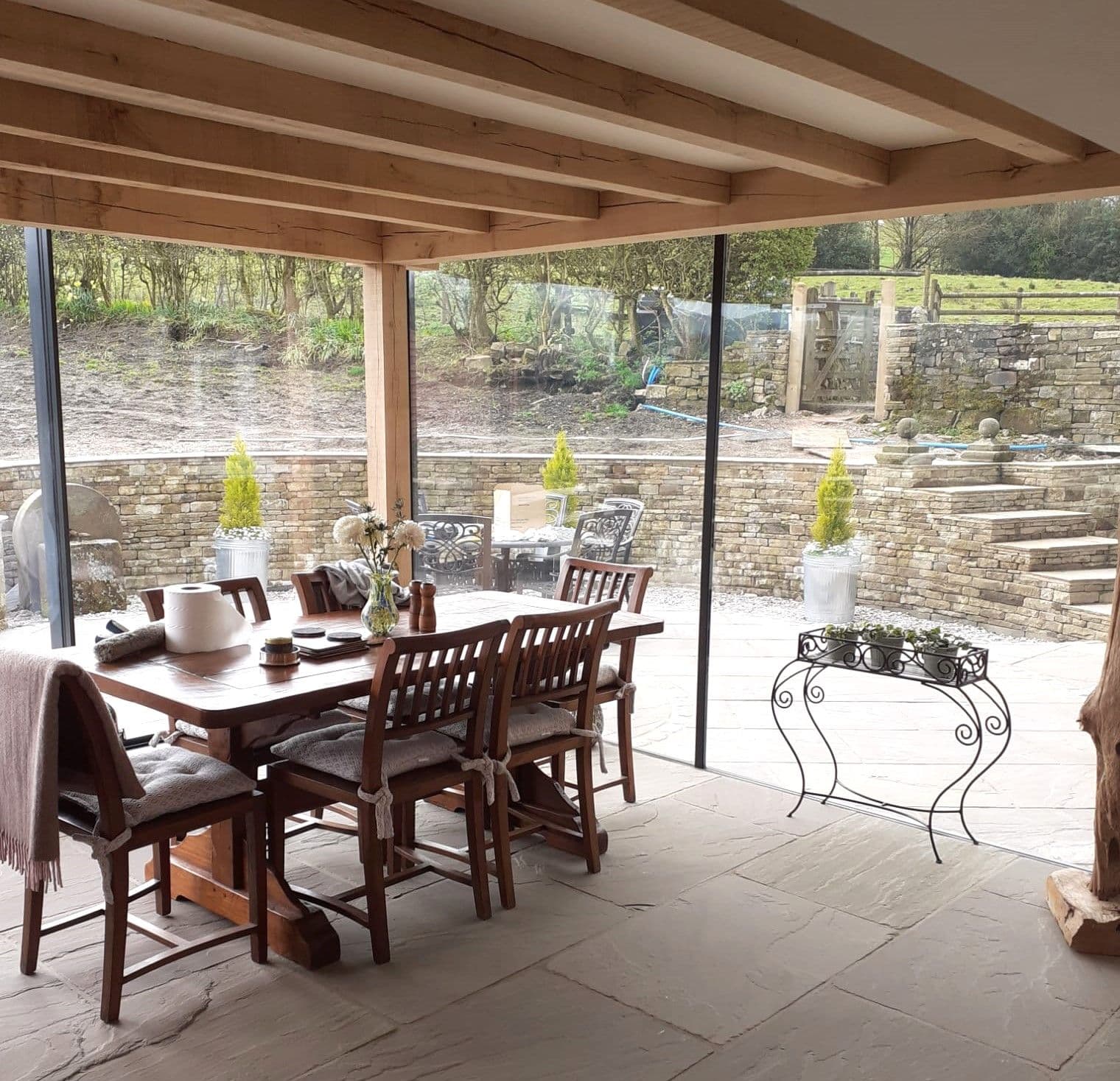 Interior of a glazed extension with slim sightlines opening onto the garden