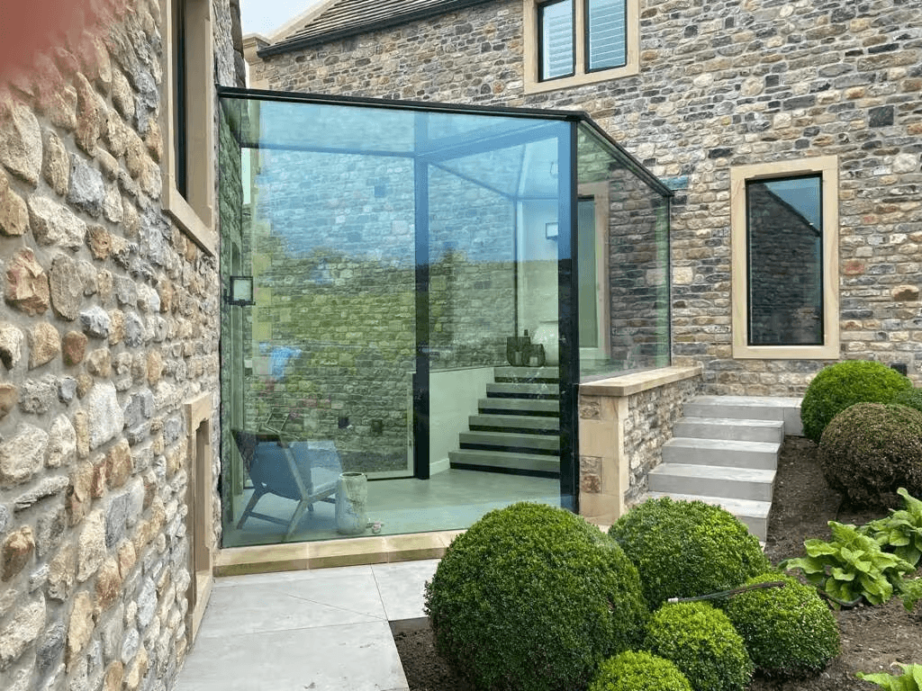 Structural glass link connecting two buildings on a residential property