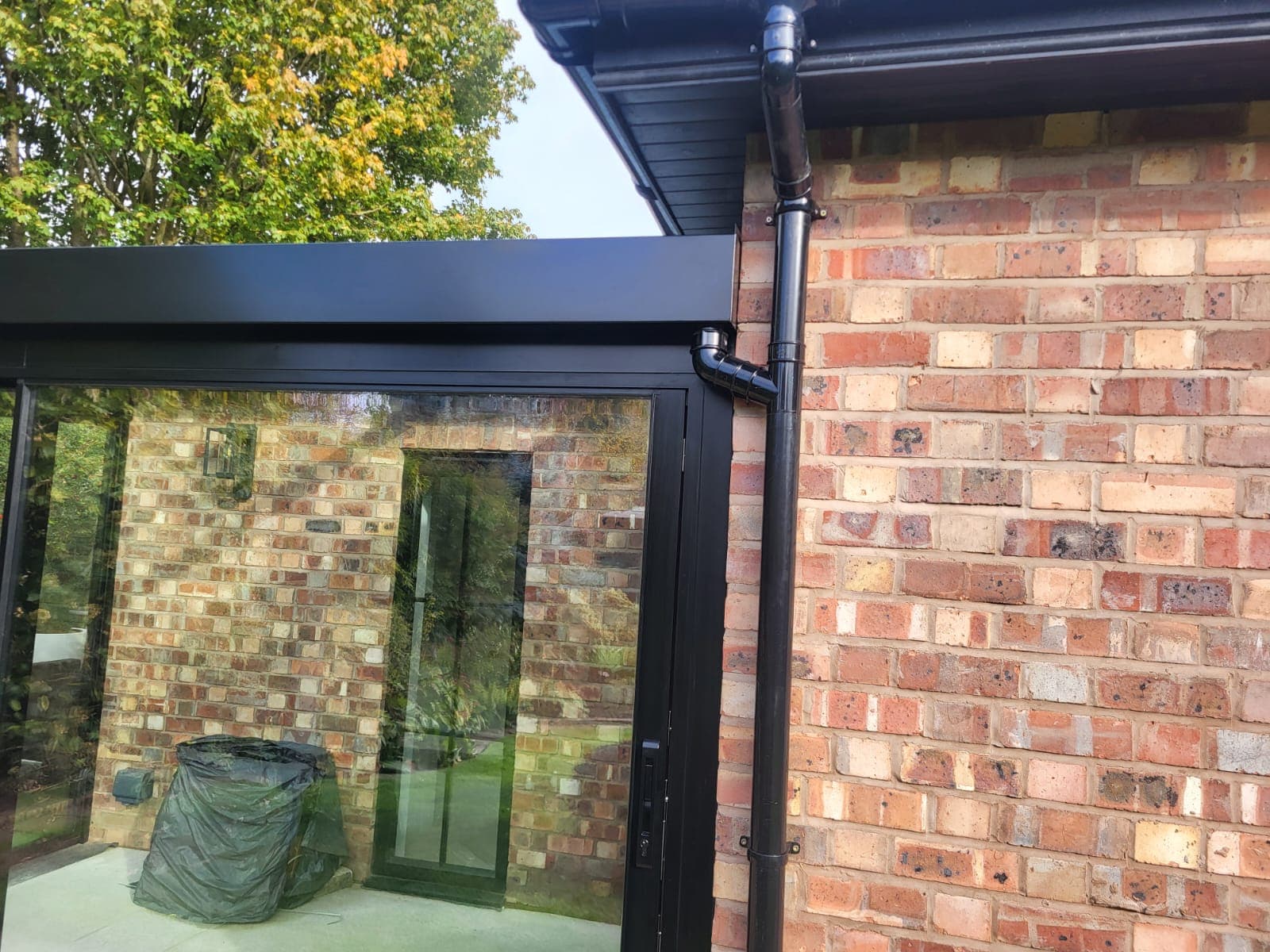 Glass box extension connecting indoor living space to the garden